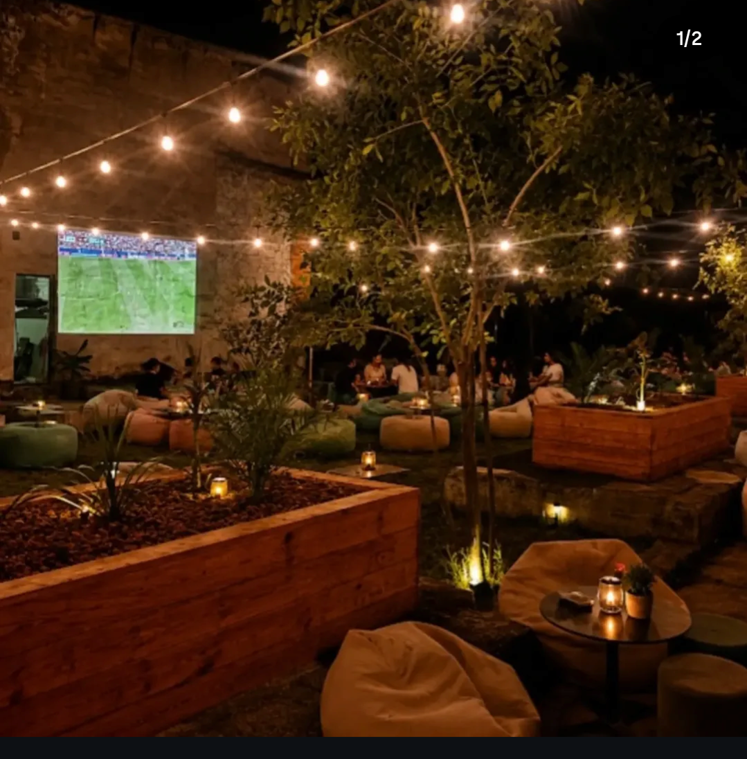 Terasa August Lounge seara, cu ghirlande de becuri și fotolii puf